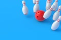 Red bowling ball crashing white falling pins on blue background Royalty Free Stock Photo