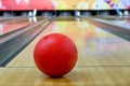 Red bowling ball put on wood alley with blurred bowling pin Royalty Free Stock Photo