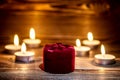 Red box with a ring on the background of burning small candle. Royalty Free Stock Photo