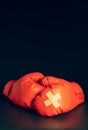 Red boxing gloves in the dark background. Adhesive plaster across each other on boxing gloves. Royalty Free Stock Photo