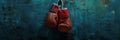 Red boxing gloves hanging on a blue wall. Banner. Textured background with copy space. Minimalistic sports equipment Royalty Free Stock Photo