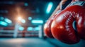 Red boxing gloves lying on the canvas of an empty boxing ring under dramatic gym lighting Royalty Free Stock Photo