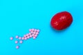 Red brain on a blue background with pink pills. Some pills for the brain. This is symbolic for drugs, psychopharmaceuticals, Royalty Free Stock Photo