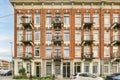 a red brick apartment building with cars parked in front Royalty Free Stock Photo