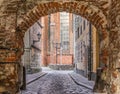 Red brick archway with a cobbled road. Royalty Free Stock Photo