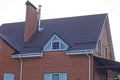 Red brick attic with a white windows and one large chimney