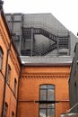 Red brick building with metal staircase on the roof, architectural background Royalty Free Stock Photo