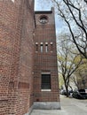 Red brick building with a row of cars parked along the pavement Royalty Free Stock Photo