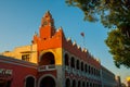 Red brick building tower with golden dome and clock in the City center of Merida. Mexican flag flutters on air. City Town hall of Royalty Free Stock Photo