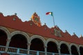 Red brick building tower with golden dome and clock in the City center of Merida. Mexican flag flutters on air. City Town hall of Royalty Free Stock Photo