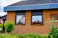 Red brick building with two windows and flowers in the window sill in Germany Royalty Free Stock Photo
