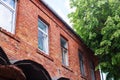 Red brick building windows and green wood Royalty Free Stock Photo