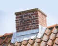 Red brick chimney designed on roof of house or building outside against a sky background. Construction frame of escape