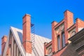 Red brick chimney on the roof, fragment of the facade of a brick building against the blue sky Royalty Free Stock Photo