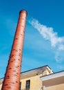 Red brick chimney with smoke on blue sky Royalty Free Stock Photo