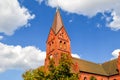 The red brick, clock tower rises above the coastal town of Warnemunde Rostock, Germany