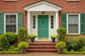 red brick colonial house with a green central front door Royalty Free Stock Photo