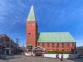 Red brick facade and green copper roof of the Nagasaki\'s Maria Hall standing on the paved Glover street.