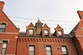 Red brick facade on residential urban apartment building with dormers and cupola