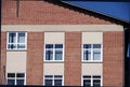 Well-kept older brick building with red facade under blue sky