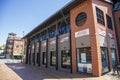 A red brick footpath at the Tennessee Aquarium with red brick buildings and lush green trees and gorgeous clear blue sky