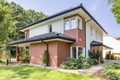 Red brick house with terrace and green grass and trees during summer Royalty Free Stock Photo