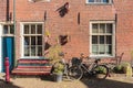 A red brick house wall, with a bench and a bicycle in front of it, in Delft, Netherlands Royalty Free Stock Photo