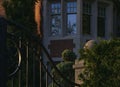 A red-brick mansion behind black iron gates at sunset