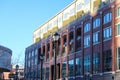 A red brick office building with recessed balconies with tall black light posts and bare winter trees and clear blue sky Royalty Free Stock Photo