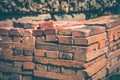 Red brick packed in stack are stored on ground outdoors at a hardware store warehouse. Building bricks on pallet on an