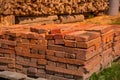 Red brick packed in stack are stored on ground outdoors at a hardware store warehouse. Building bricks on pallet on an