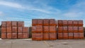 Red brick packed in stacks are stored on ground outdoors at a hardware store warehouse. Building bricks on pallets on an outdoor.