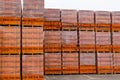 Red brick packed in stacks are stored on ground outdoors at a hardware store warehouse. Building bricks on pallets on an outdoor.