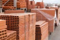 Pallets with stack of redbricks lying at warehouse