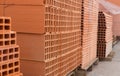 Pallets with stack of redbricks lying at warehouse