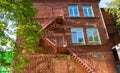 Red brick residential building. Metal staircase outside on the facade of the house Royalty Free Stock Photo