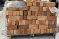 Red brick stowed on a wooden flight at a construction site.