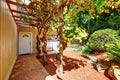 Red brick walkway leading to the front door of beige house.