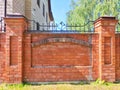 Red Brick Wall With Arch Detail in Urban Setting. Red brick wall featuring an arch design on a sunny day Royalty Free Stock Photo