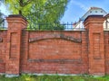 Red Brick Wall With Arch Detail in Urban Setting. Red brick wall featuring an arch design on a sunny day Royalty Free Stock Photo