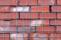 Red brick wall behind wire fence, abstract background and symmetry Royalty Free Stock Photo