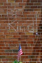 Red brick wall chalk inscription Be Kind and flag of the USA