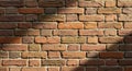 Red brick wall composed of rectangular bricks arranged in a staggered pattern. The Royalty Free Stock Photo