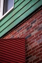 Red brick wall corner and awning with green and blue painted wood