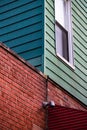 Red brick wall corner with green and blue painted wood