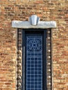 Red brick wall with art deco stained glass window and lintel