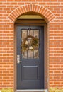 Red brick wall with nice brown door. Exteriror of a house