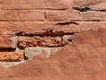 Red brick wall of an old building with crumbling plaster. Copy space. Selective focus Royalty Free Stock Photo