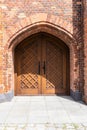 A red brick wall and old doors. Background of an old brick wall with a wooden door. Royalty Free Stock Photo