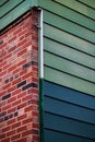 Red brick wall section with green and blue painted wood